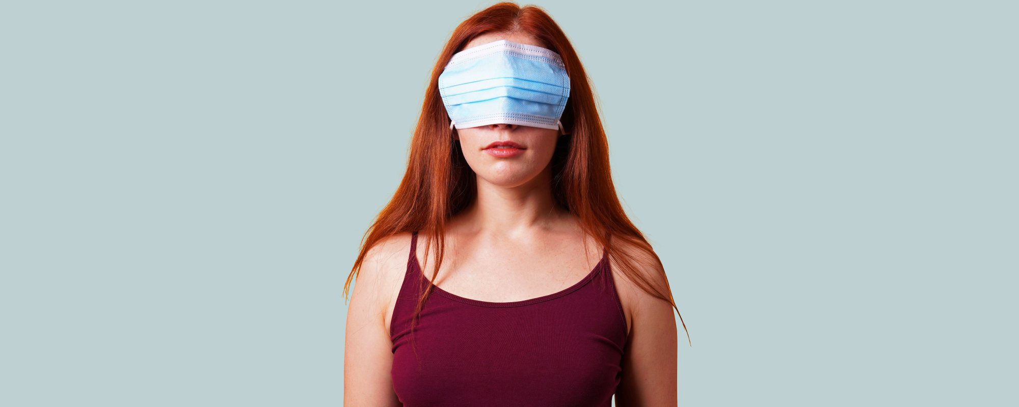 Woman with a mask covering her eyes.